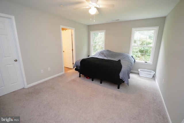carpeted bedroom featuring multiple windows, ceiling fan, and baseboards