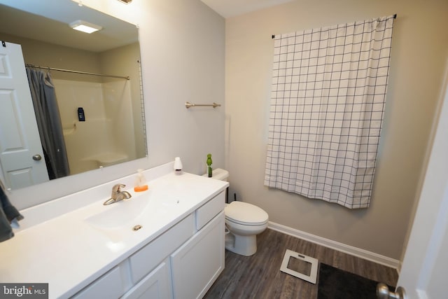 full bathroom featuring a shower with shower curtain, toilet, vanity, wood finished floors, and baseboards