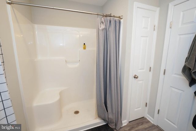 bathroom featuring a shower with shower curtain and wood finished floors