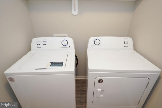 laundry area featuring independent washer and dryer, wood finished floors, and laundry area