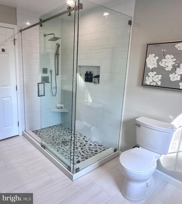 bathroom with a shower stall and toilet