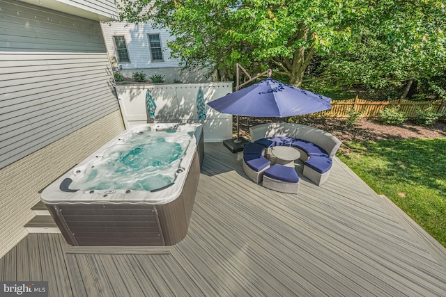 deck with a hot tub and fence