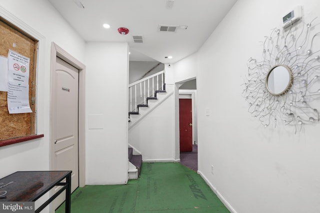 interior space with carpet floors, recessed lighting, visible vents, and stairway