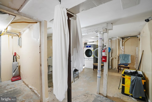 unfinished below grade area with washing machine and clothes dryer