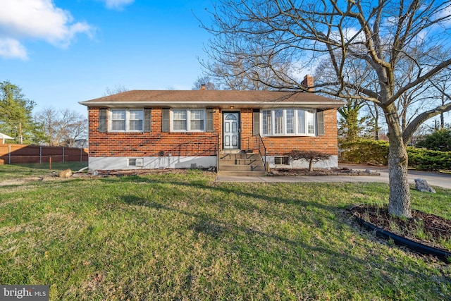 view of front of house with brick siding, a front yard, fence, and a chimney