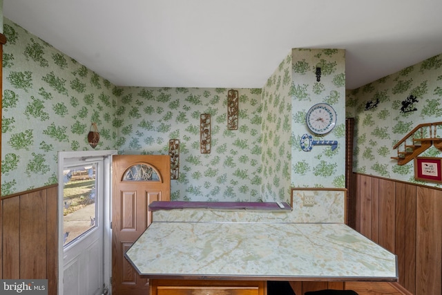 dining space featuring a wainscoted wall and wallpapered walls