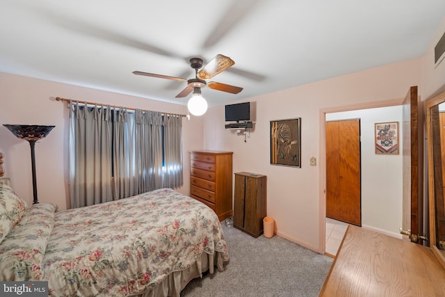 bedroom featuring baseboards, light colored carpet, and a ceiling fan