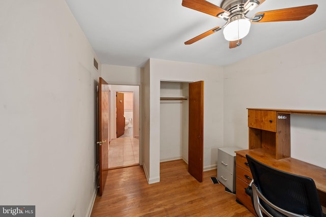 home office with baseboards, visible vents, light wood-style flooring, and ceiling fan