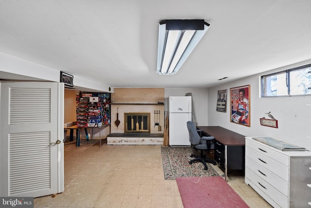 office area featuring a brick fireplace and light floors