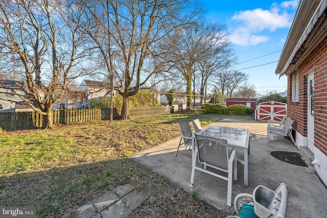 view of patio / terrace with outdoor dining space, a shed, an outdoor structure, and fence private yard