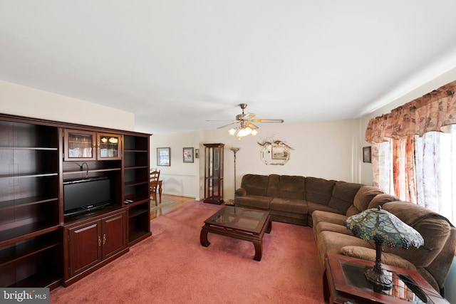 living area with a ceiling fan and light carpet