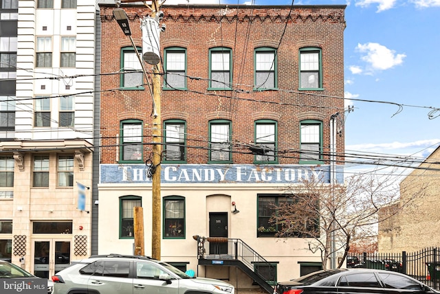 view of front facade featuring brick siding and fence