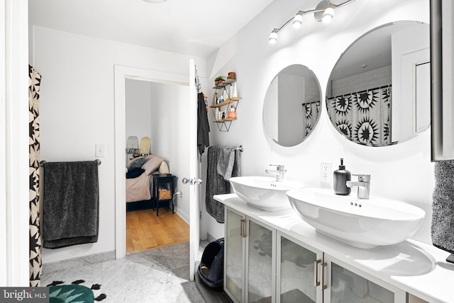 ensuite bathroom featuring ensuite bathroom, double vanity, and a sink