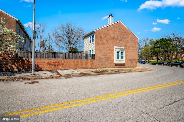 820 S Paca St, Baltimore, MD 21230 - view of side of home featuring a chimney, fence, and brick siding