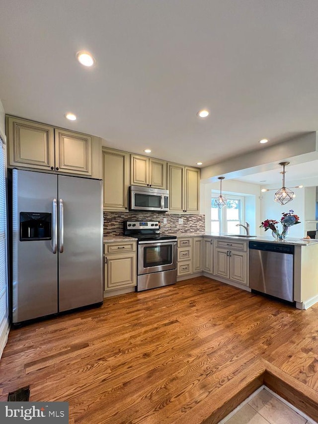 820 S Paca St, Baltimore, MD 21230 - kitchen with tasteful backsplash, cream cabinets, a sink, appliances with stainless steel finishes, and wood finished floors