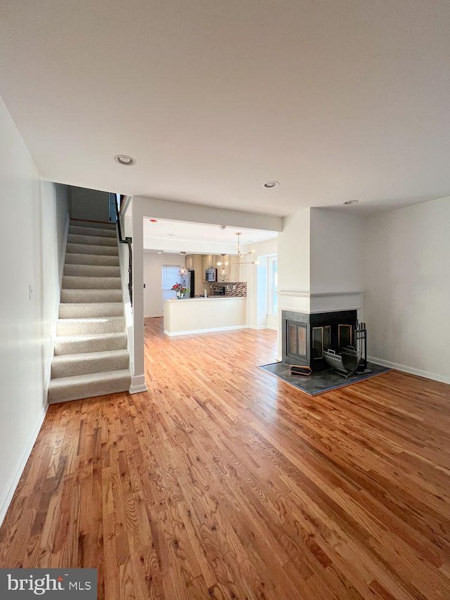 820 S Paca St, Baltimore, MD 21230 - unfurnished living room featuring baseboards, stairway, and wood finished floors