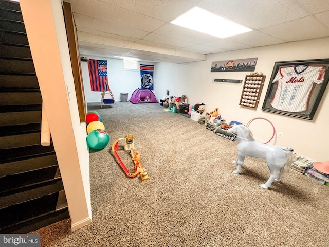 playroom featuring carpet flooring and a paneled ceiling