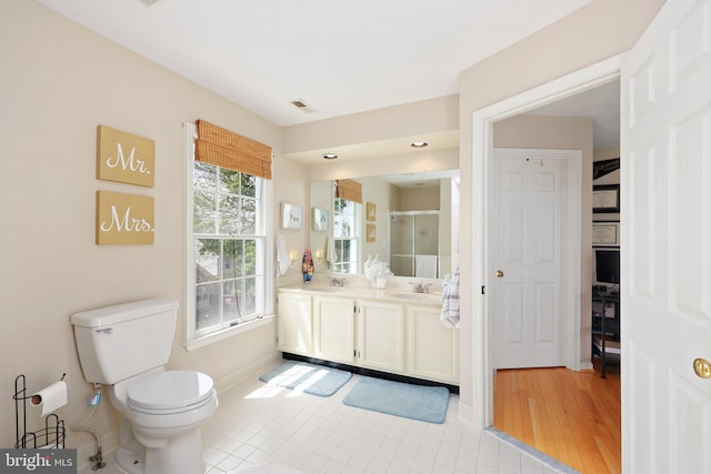 bathroom with a sink, double vanity, toilet, visible vents, and a shower stall