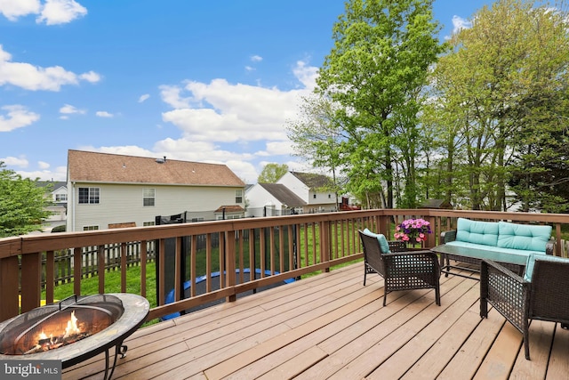 wooden deck with a residential view and an outdoor living space with a fire pit