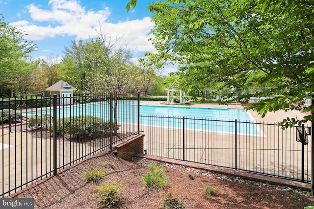 community pool with fence and a patio