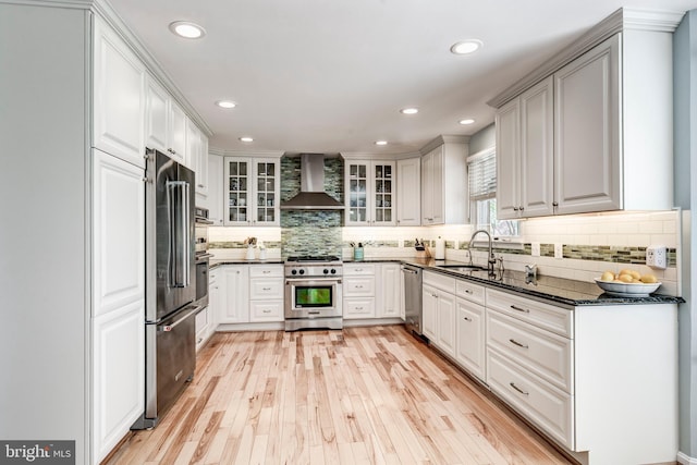 5855 Springmount Ct, Eldersburg, MD 21784 - kitchen with a sink, wall chimney exhaust hood, high quality appliances, decorative backsplash, and light wood-style flooring