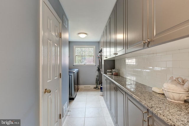 5855 Springmount Ct, Eldersburg, MD 21784 - clothes washing area with light tile patterned floors, washer and dryer, cabinet space, baseboards, and visible vents