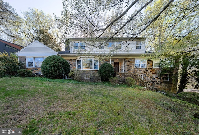 traditional home featuring a front lawn and stone siding