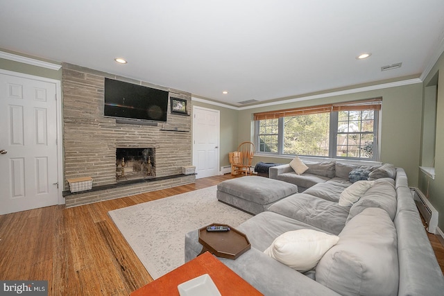 living area with ornamental molding, a fireplace, a baseboard radiator, and visible vents
