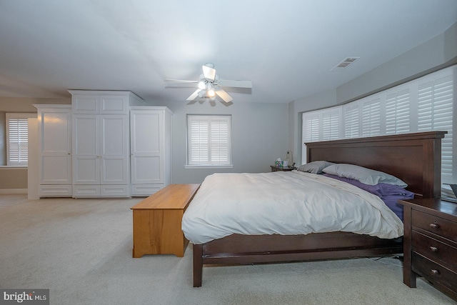 bedroom featuring a ceiling fan, light carpet, and visible vents