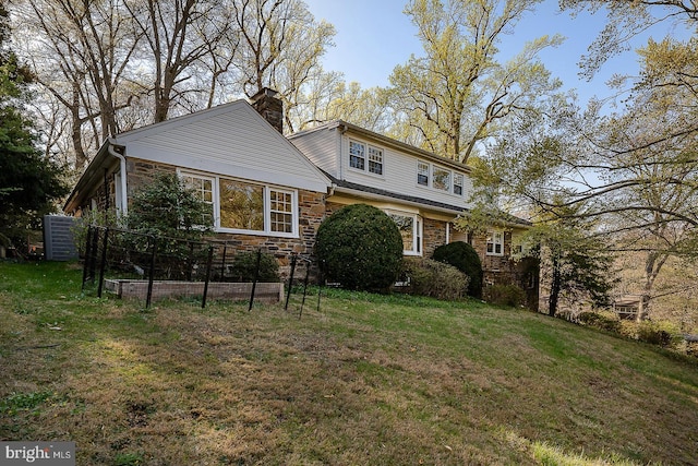 exterior space with a front lawn, a chimney, and stone siding