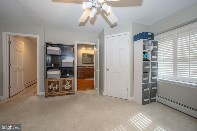 unfurnished bedroom with a baseboard heating unit, ensuite bathroom, carpet flooring, and a ceiling fan