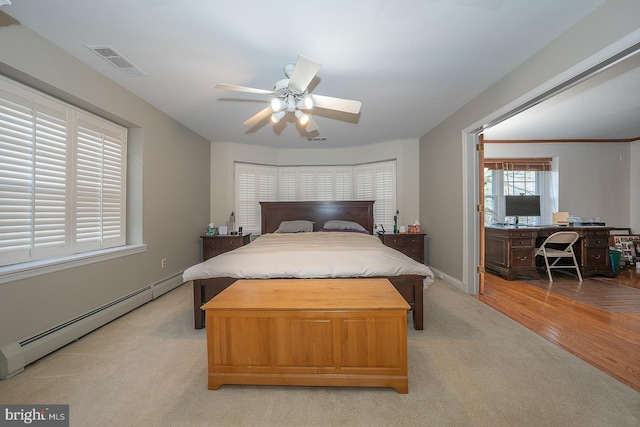 bedroom with a ceiling fan, a baseboard radiator, baseboards, visible vents, and light colored carpet