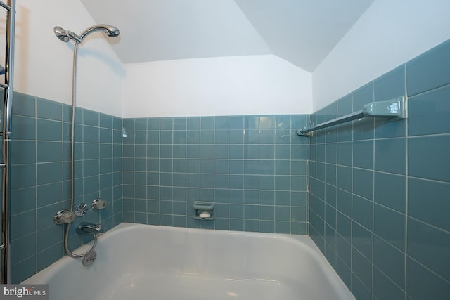 bathroom with shower / bathing tub combination and lofted ceiling