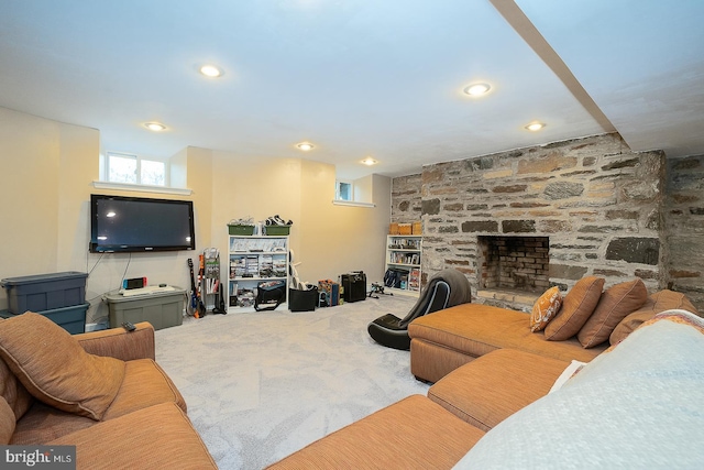 carpeted living area with a stone fireplace