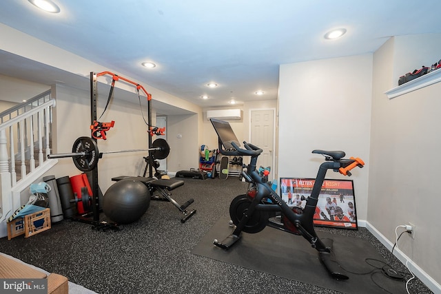 workout area with baseboards, a wall unit AC, and recessed lighting