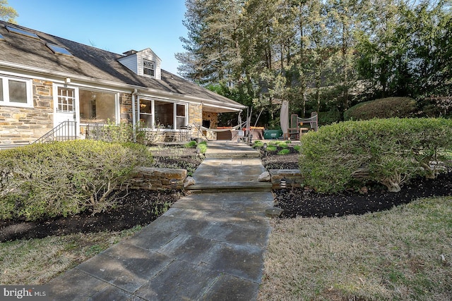 view of exterior entry with a patio and stone siding