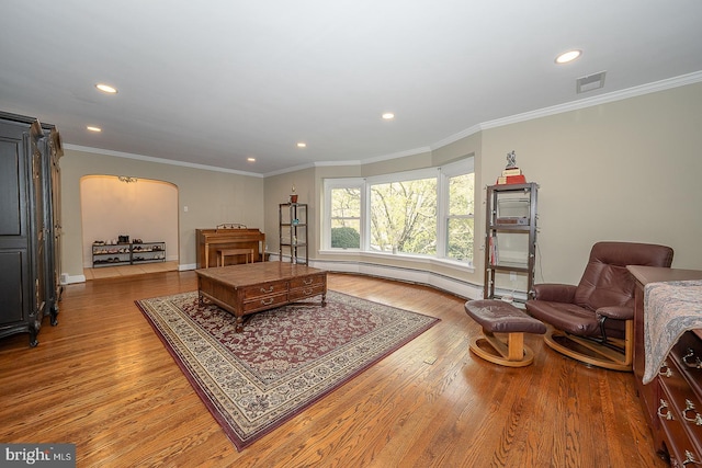 living area featuring wood finished floors, baseboards, arched walkways, and recessed lighting