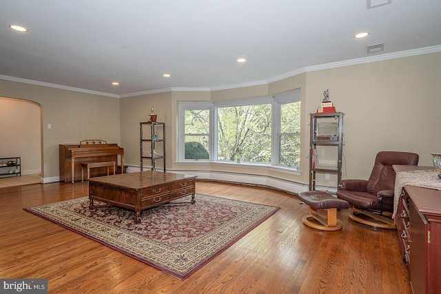 living area with recessed lighting, arched walkways, visible vents, and wood finished floors
