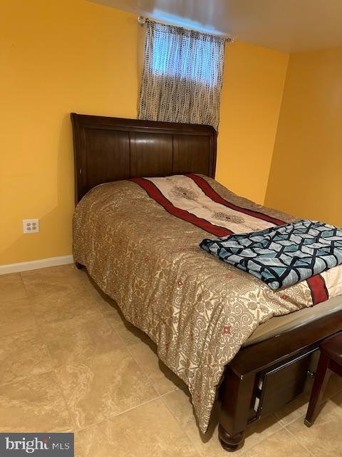 bedroom featuring light tile patterned floors and baseboards