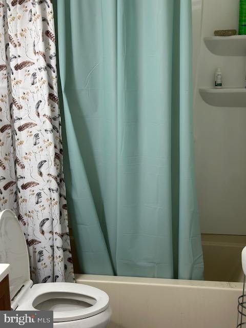 full bathroom featuring shower / bath combo, toilet, and vanity