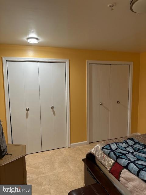 bedroom with two closets and baseboards