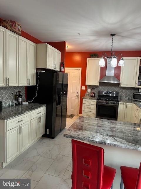 kitchen featuring stainless steel appliances, marble finish floor, tasteful backsplash, and wall chimney exhaust hood