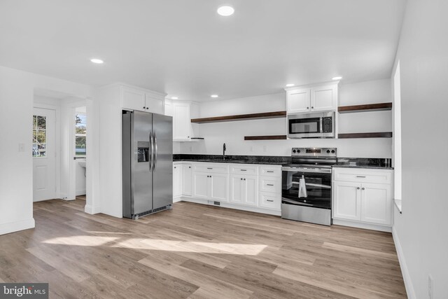 kitchen featuring white cabinets, stainless steel appliances, dark countertops, recessed lighting, and open shelves