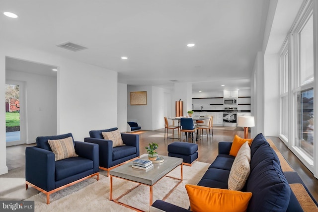 living area featuring wood finished floors, visible vents, and recessed lighting
