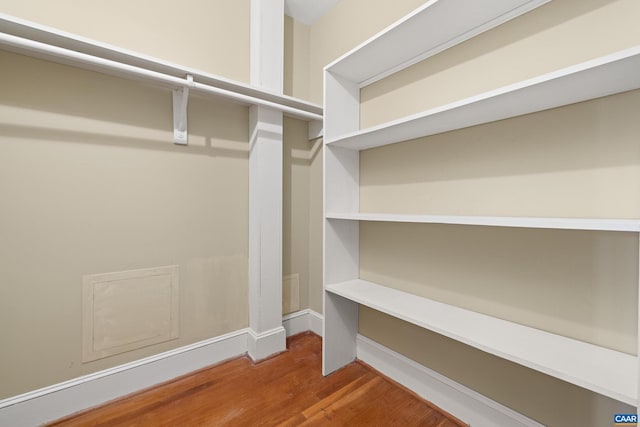 walk in closet with wood finished floors