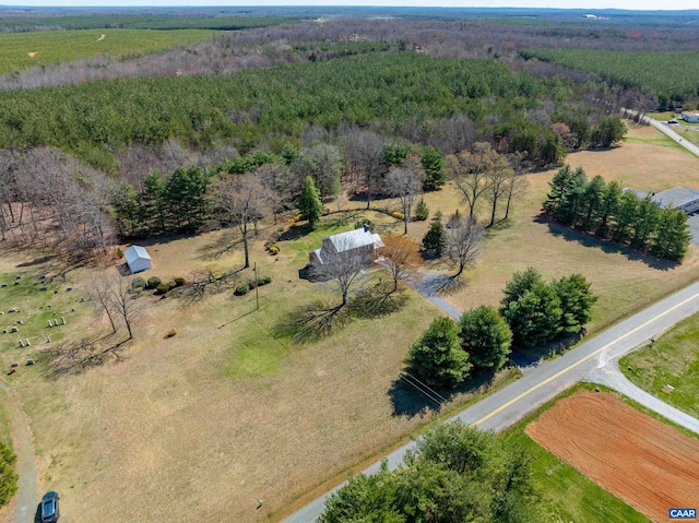 drone / aerial view with a wooded view and a rural view