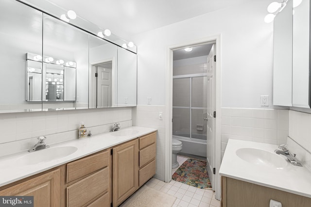 1406 Gentlemens Way, Dresher, PA 19025 - bathroom with tile walls, double vanity, tile patterned flooring, bath / shower combo with glass door, and wainscoting