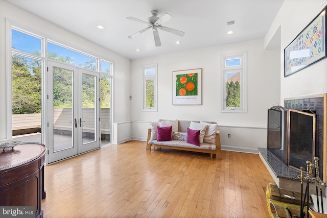 1406 Gentlemens Way, Dresher, PA 19025 - living area with a fireplace with raised hearth, light wood-style flooring, a ceiling fan, french doors, and recessed lighting