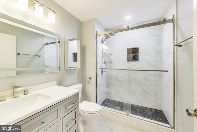 bathroom with toilet, a shower stall, and vanity