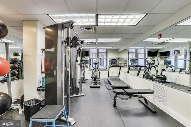 gym with visible vents, baseboards, and a drop ceiling